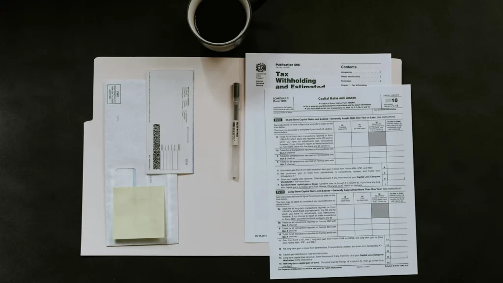 Financial and tax documents arranged on a desk, including tax forms, envelopes, and paperwork used as proof of financial means for visa application.