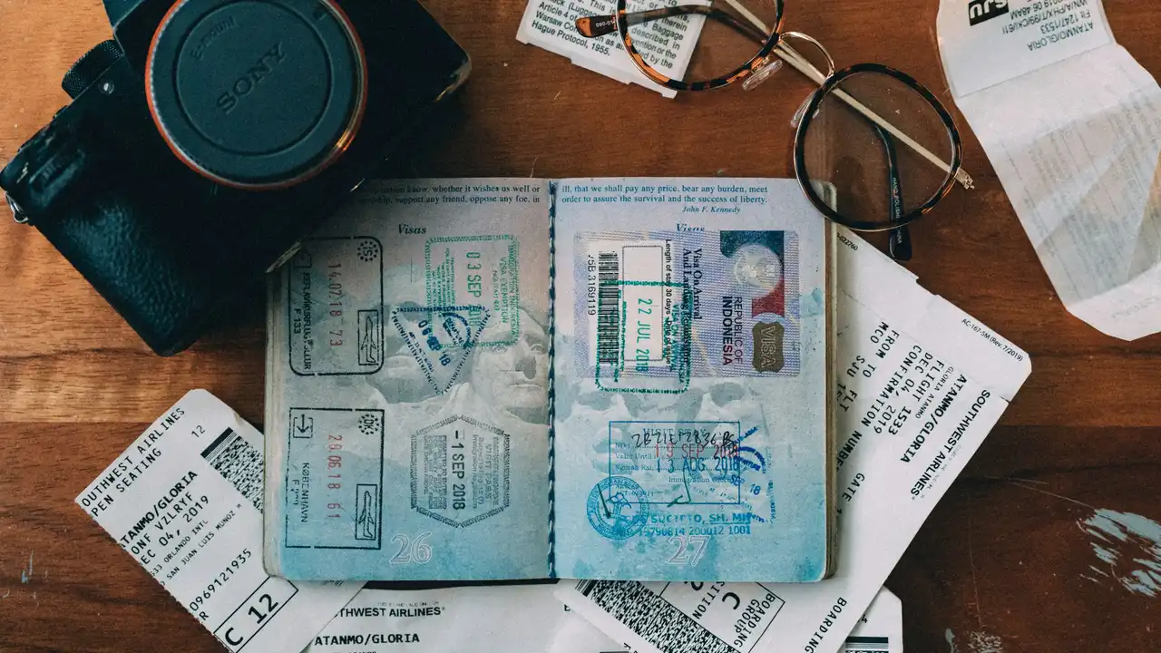 Open passport displaying multiple visa stamps alongside travel documents and boarding passes, representing different types of Estonian visas for international travel.