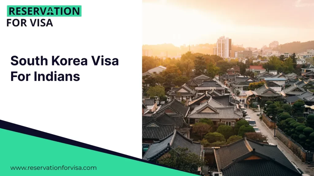 A sunset view over a traditional Korean village featuring densely packed Hanok houses with dark-tiled roofs, set against a backdrop of modern city buildings and trees.