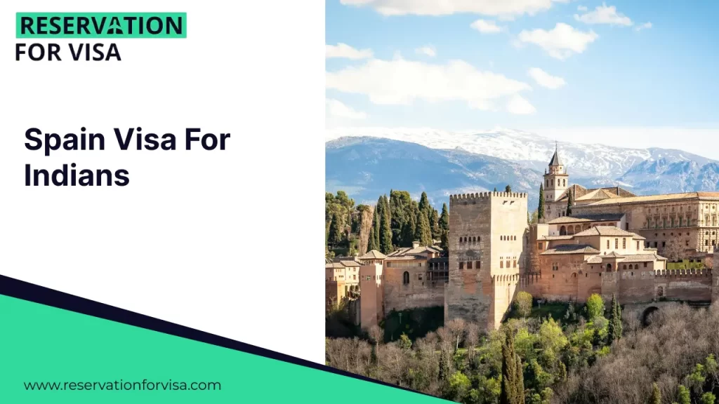 A panoramic view of the Alhambra palace complex in Granada, Spain, featuring its iconic red stone fortress walls and towers nestled among green trees with snow-capped mountains in the far background.